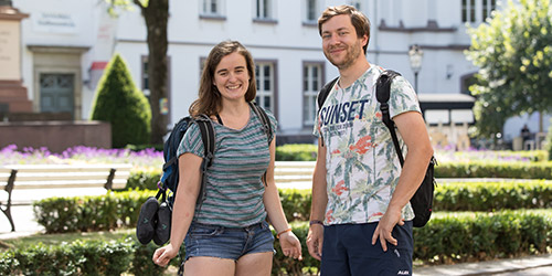 Photo: Two students on campus smiling at the camera